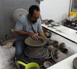photo of man working on pottery wheel